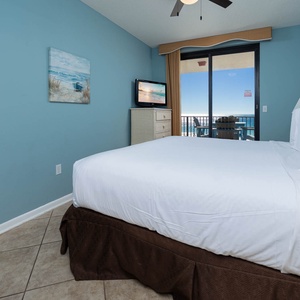 Relax in the comfortable master bedroom featuring a plush king bed, vibrant decor, and balcony access