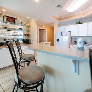 Enjoy morning coffee at the sleek bar counter, surrounded by a bright, inviting kitchen vibe
