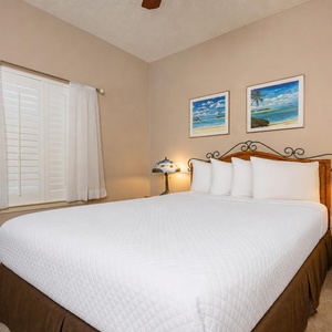 Rest comfortably in this inviting guest bedroom, featuring a plush queen bed, soft lighting, and charming decor