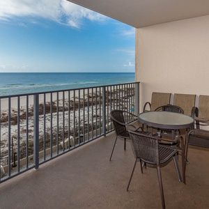 Enjoy meals or drinks at the outdoor table surrounded by comfortable seating and serene views of the beach