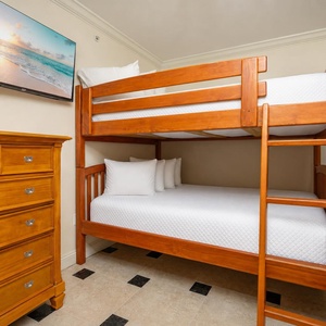 Enjoy a cozy sleeping space with a sturdy twin bunk bed, a dresser, and a TV for entertainment during your stay