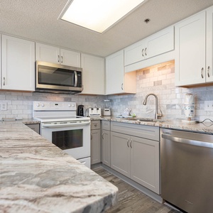 Kitchen featuring stylish countertops, modern cabinetry, and a breakfast bar, perfect for preparing meals