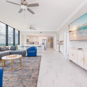 Unwind in the inviting living area, featuring a plush sectional, vibrant chairs, and a large TV for entertainment