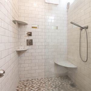 Spacious master bath walk-in shower with elegant tile and glass enclosure for a refreshing experience