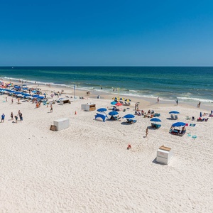 Enjoy stunning beach views with colorful umbrellas and sunbathers from this inviting living area, perfect for relaxation
