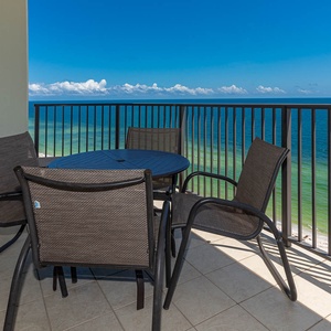 Enjoy the fresh air on the balcony, featuring a round table and chairs with stunning views of the tranquil waters