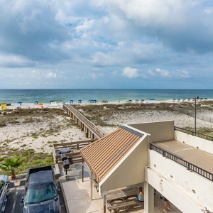 This inviting view showcases a beachfront area with colorful umbrellas, a boardwalk, and a relaxing outdoor seating space