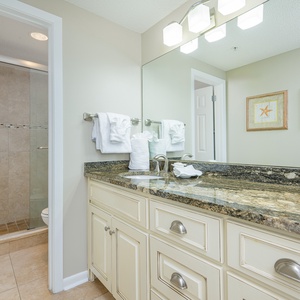 Refresh in the stylish master bathroom featuring a spacious granite vanity, modern lighting, and a walk-in shower