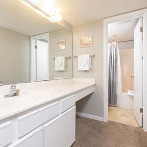 Bright master bathroom featuring a spacious countertop, modern fixtures, and a tub/shower combo, for a refreshing retreat
