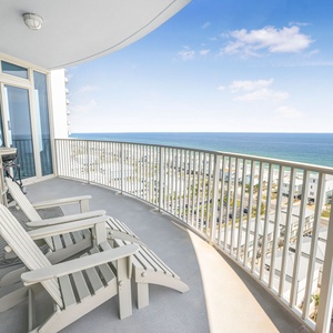 Enjoy breathtaking beach views from this balcony, featuring comfortable seating and a stylish table for relaxation