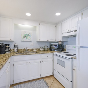 The kitchen features white cabinets, granite countertops, and modern appliances, perfect for preparing meals during your stay