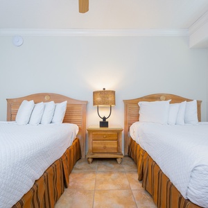 Warmly colored walls complement two comfortable double beds and a TV, creating a cozy retreat for relaxation