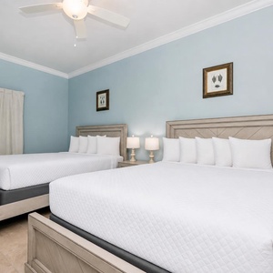 Rest in this tranquil guest bedroom featuring two queen beds and calming decor for a relaxing stay