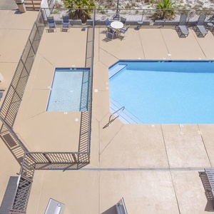 This view showcases a sparkling pool and hot tub surrounded by lounge chairs, perfect for relaxation and fun in the sun