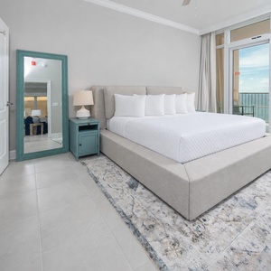 Relax in the king master suite with cozy bedding and drift off to the sound of the waves from the balcony