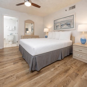Guest bedroom featuring a queen bed, stylish decor, and a convenient en-suite bathroom entrance nearby