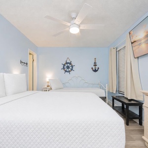 Unwind in this serene guest room with a queen and a twin bed and a cozy atmosphere as you prepare for exciting beach days