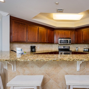 Savor morning coffee at the stylish breakfast bar, embraced by warm wood tones and cheerful coastal vibes