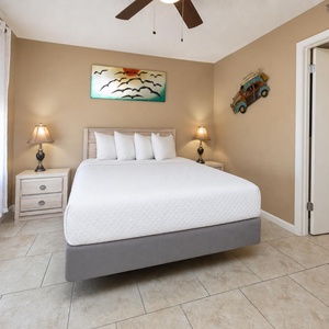 In this queen guest suite, gentle lamp glow and peaceful art help you unwind after busy beach days