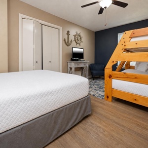 Cozy guest room featuring a twin over full bunk bed, additional double bed, and a TV
