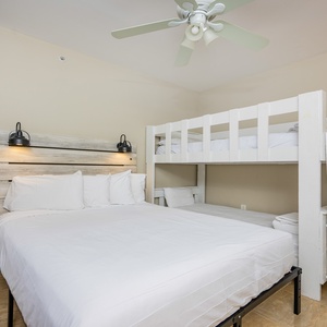 Guest bedroom featuring a comfortable queen bed and a charming twin bunk bed, perfect for family or group stays
