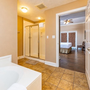 Your master suite bathroom welcomes calm with a soothing tub and glass shower space for relaxing refreshment
