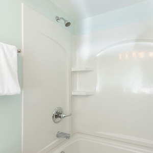 Refreshing guest bathroom featuring a clean tub/shower combo and plush white towels for a refreshing stay