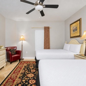 Two doubles in the guest suite offer a cozy night's rest with soft lamps casting a gentle glow nearby