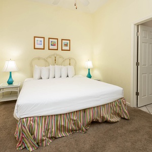 Cozy king bed, with a charming nightstand and inviting art enhancing the guest room's warmth