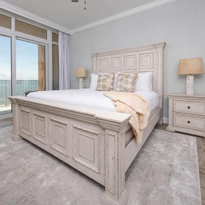 Retreat to the king master suite with cozy bedding and drift off to the sound of the waves from the balcony