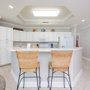 Savor your morning coffee at the cozy bar seating, surrounded by cheerful beach-themed decor