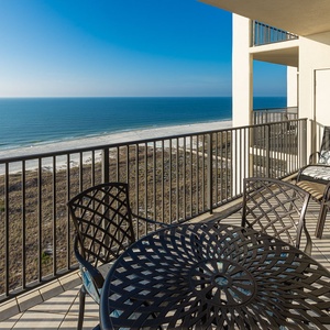 Balcony seating offers a serene view of the tranquil beach and glistening gulf waters, perfect for relaxation and enjoyment