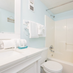Indulge in a refreshing bath experience with soft towels and beach decor, enhancing your coastal retreat