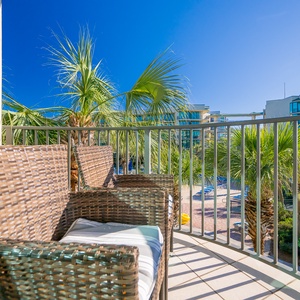 Relax in comfortable rattan chairs on the balcony, enjoying the warm breeze and views of swaying palms
