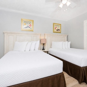 Rest comfortably in this inviting guest bedroom featuring double beds, soft linens, and tasteful decor for a relaxing stay