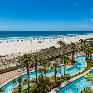 Your eyes follow the lazy river winding past swaying palms as waves gently lap the beach shore nearby