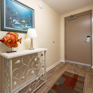 Step into a welcoming entryway featuring a decorative fish sculpture, stylish lamp, and a charming console table