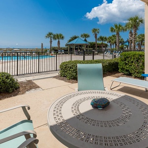 Relax at the outdoor table, enjoying the pool view and gentle breeze while soaking up the sun on your getaway