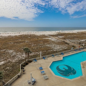 Gulf views stretch beyond the pool area, featuring lounge chairs and a vibrant mural in the water for a fun atmosphere