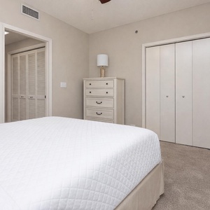 Serene guest bedroom featuring a double bed, a stylish dresser, and ample closet space for a comfortable stay