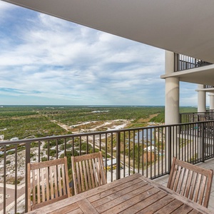This balcony offers a stunning state park view and features a wooden dining set, perfect for enjoying meals outdoors
