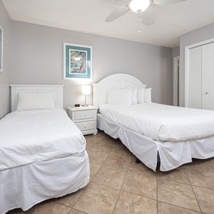 Guest bedroom featuring two comfortable beds, a queen and a twin, and stylish artwork on the walls