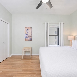 Calm guest suite invites you to relax under the ceiling fan after a day of coastal fun
