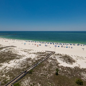Stunning view of the beach with colorful umbrellas and a clear blue sky, perfect for a relaxing day