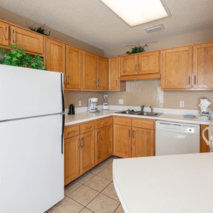 Kitchen with wooden cabinets, white appliances, and a spacious countertop, perfect for preparing meals