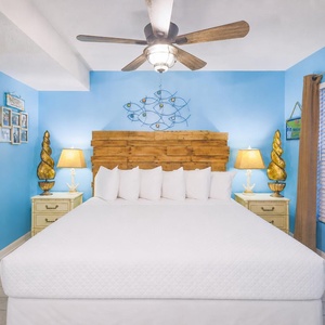 The bedroom features a cozy king bed, charming blue walls, and decorative accents, perfect for a relaxing getaway