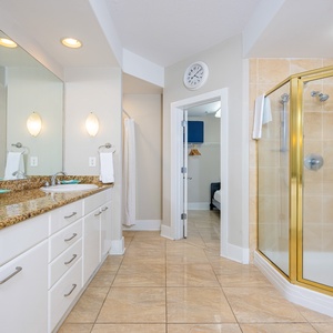 Bright and inviting bathroom featuring a spacious walk-in shower and elegant granite countertops with dual sinks