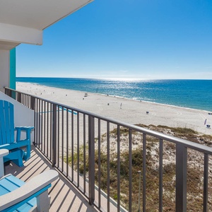 Enjoy breathtaking beachfront views from this inviting balcony with comfortable seating, perfect for relaxation