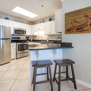 Gather around the kitchen bar with seating, where you can prepare meals and enjoy beach decor