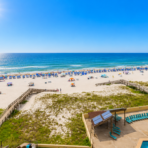 Sun casts sparkling trails across the coast as you stretch out poolside on the loungers below